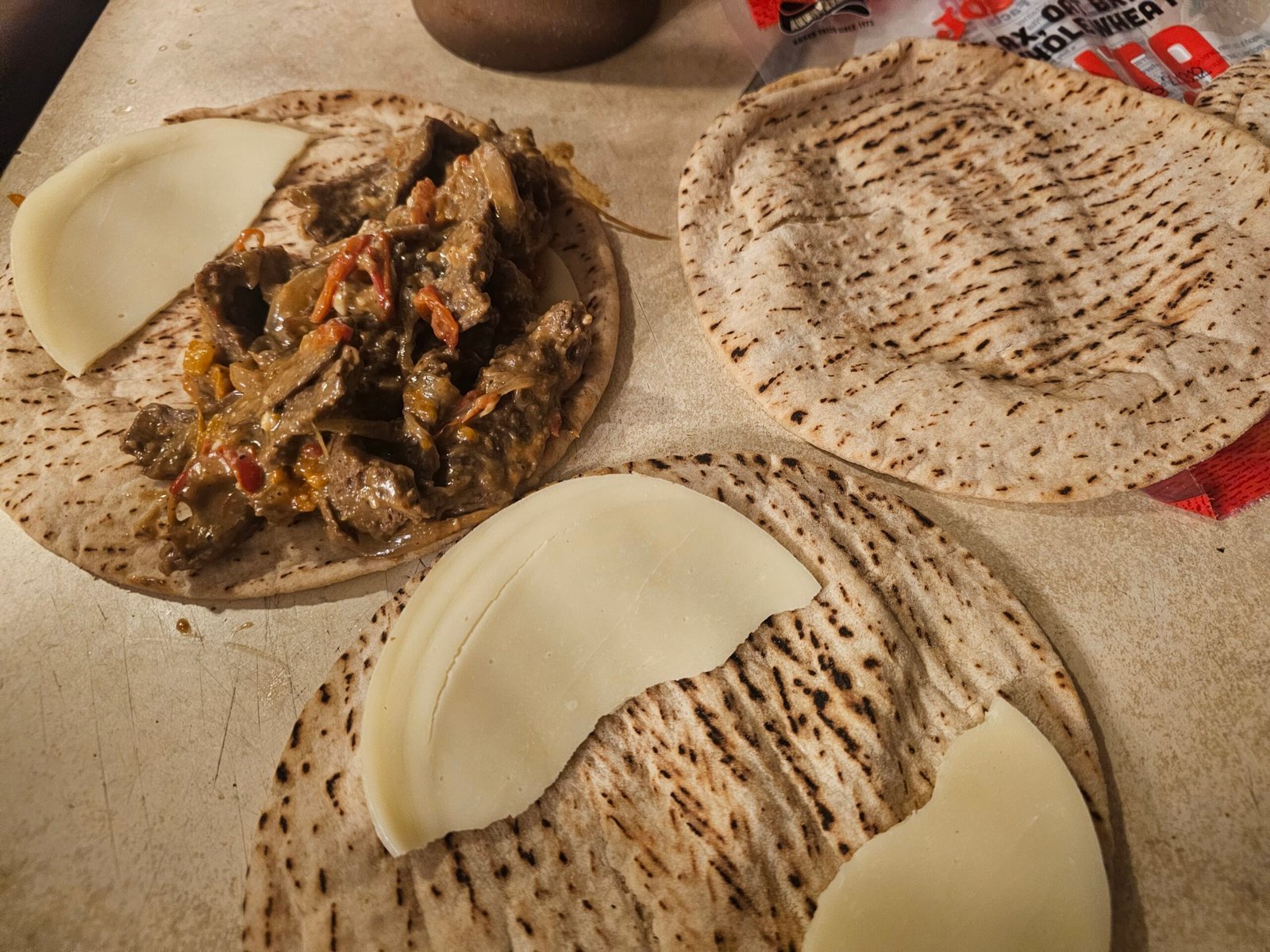 Provolone and Philly cheesesteak filling arranged inside a pita